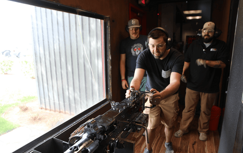beginner learning how to shoot with instructors watching and instructing